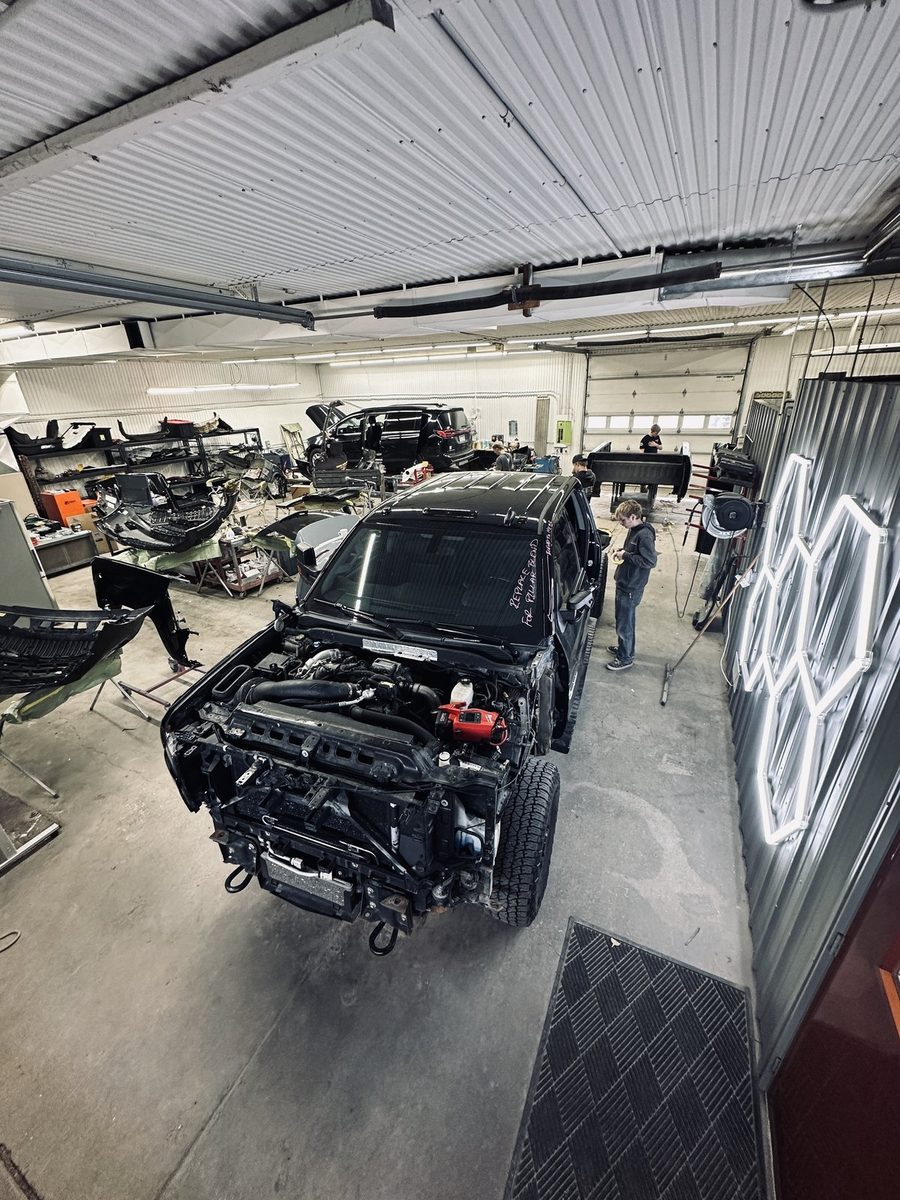 Inside United Auto Body shop in Cokato, MN — multiple vehicles being repaired by the crew